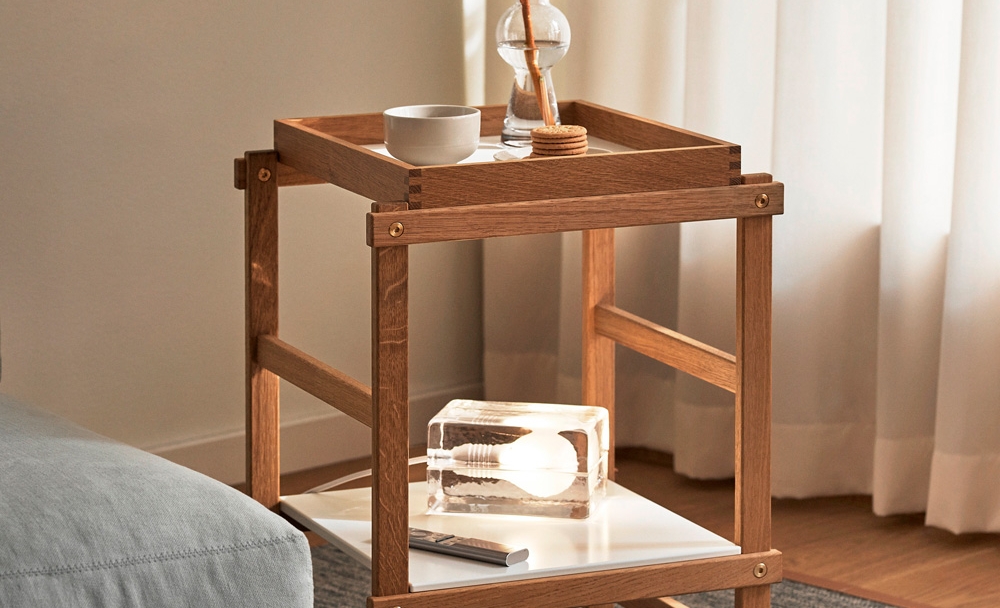 Yksityiskohta puisista huonekaluliitoksista, joissa on lohenpyrstöliitos ja messinkipultti kiskossa.