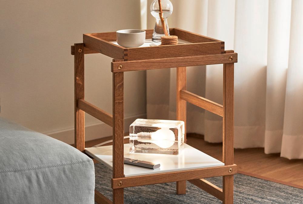 Yksityiskohta puisista huonekaluliitoksista, joissa on lohenpyrstöliitos ja messinkipultti kiskossa.