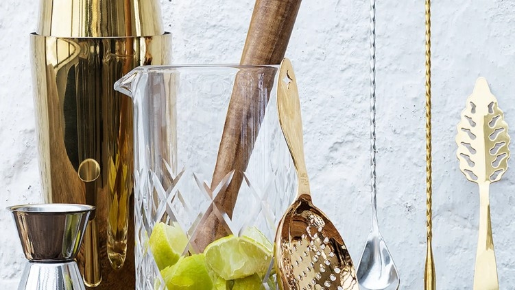 Muddlare med lime i glasbehållare med bartillbehör vid sidan