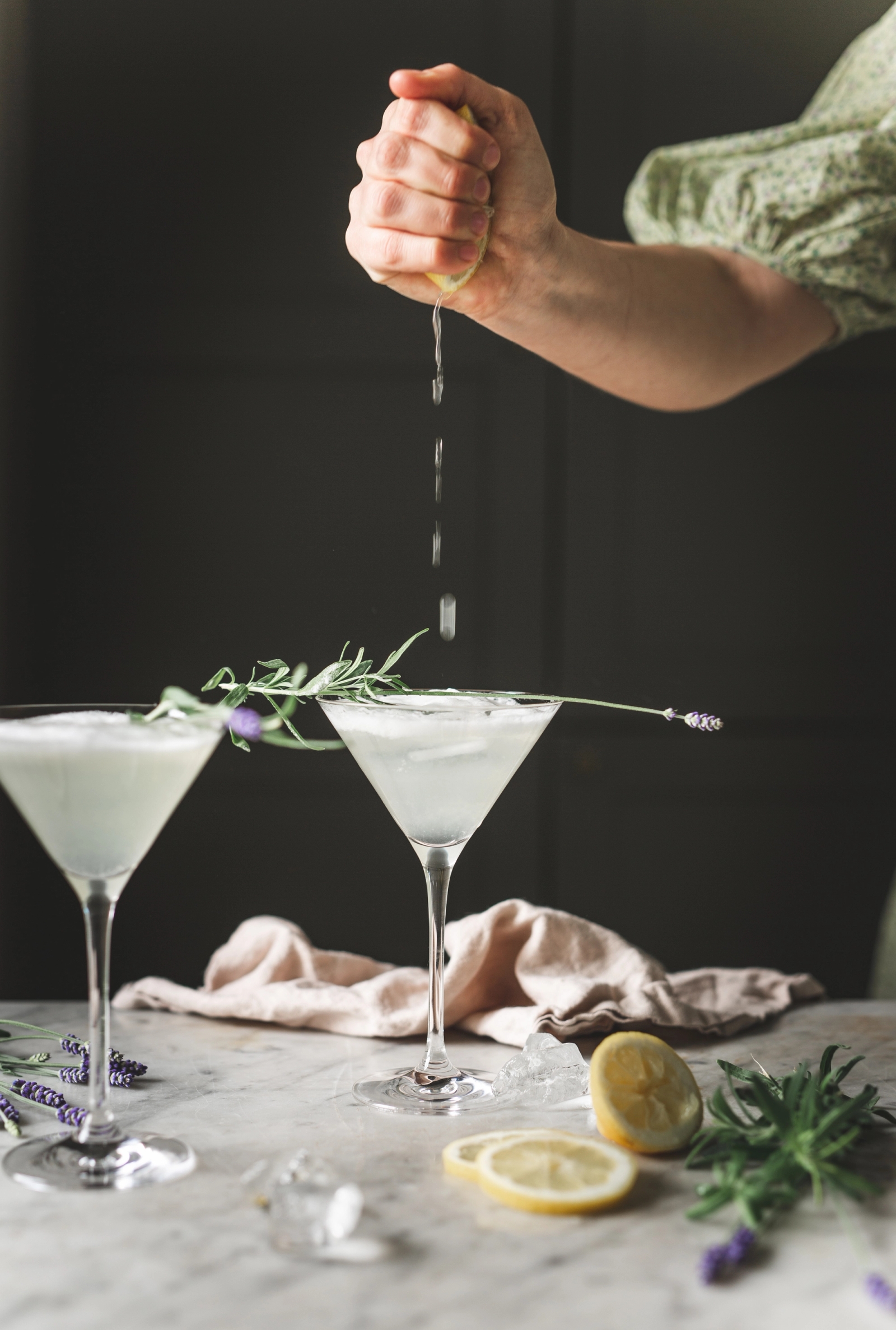 Martiniglas med en drink på marmorbänk med citron