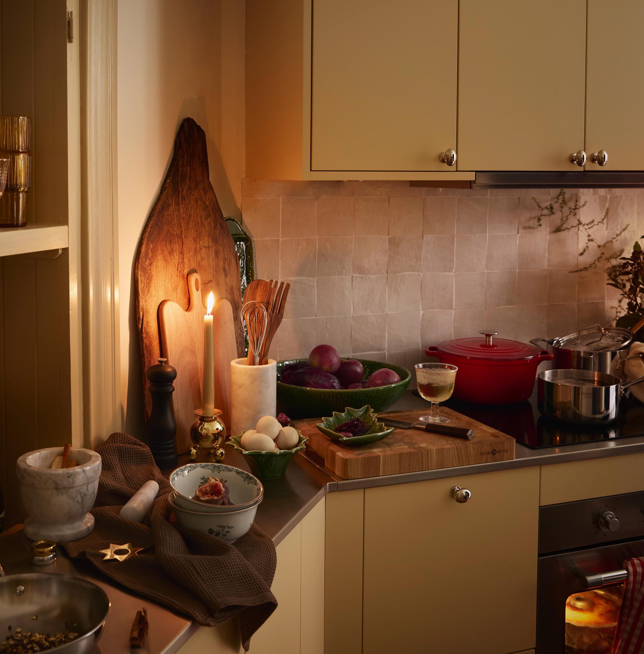 Et kjøkken med gule skap og et skjærebrett på benkeplaten