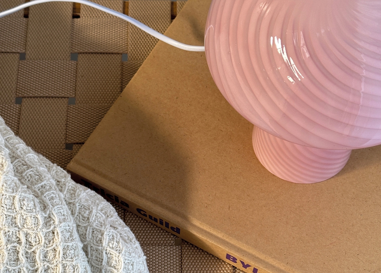 Vaaleanpunainen sienilamppu kirjan päällä