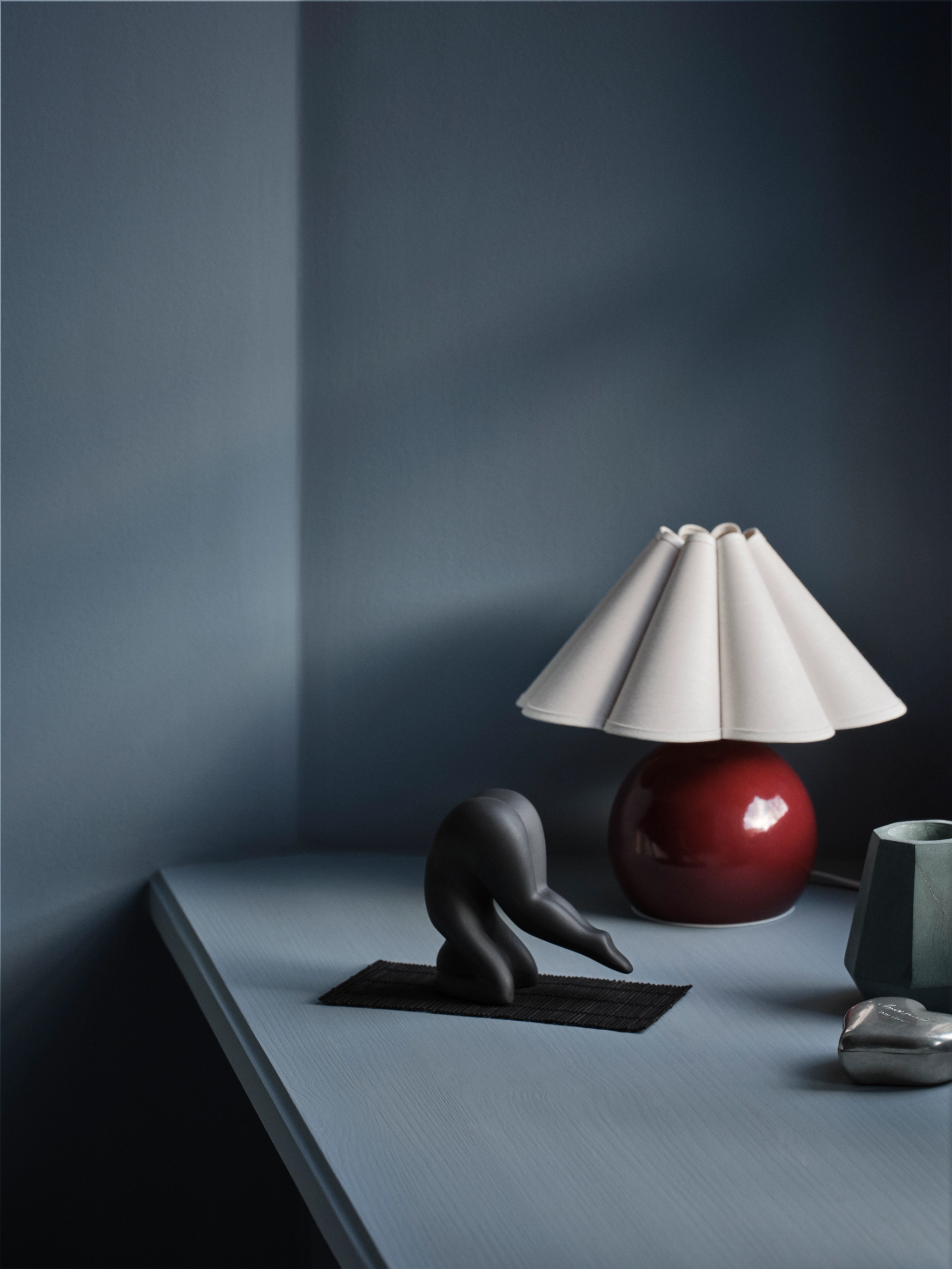 Lisa Larson Yoga figur i svart mot en mörkblå bakgrund