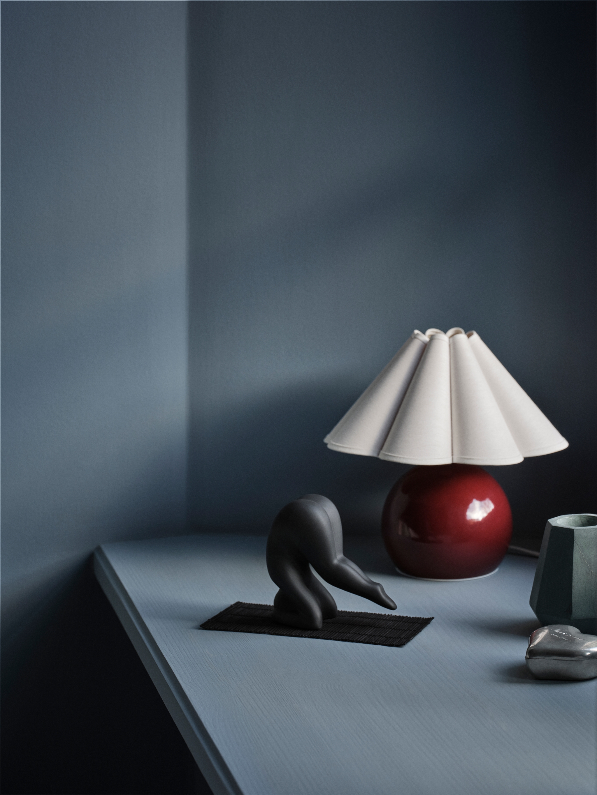 Lisa Larson Yoga figur i svart mot en mörkblå bakgrund