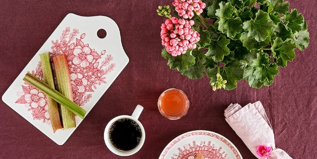 Brickor & Underlägg, Huvila serveringsbricka med rabarber på uppdukat på bord med kaffe och kaka och blomma med gröna blad och rosa blommor