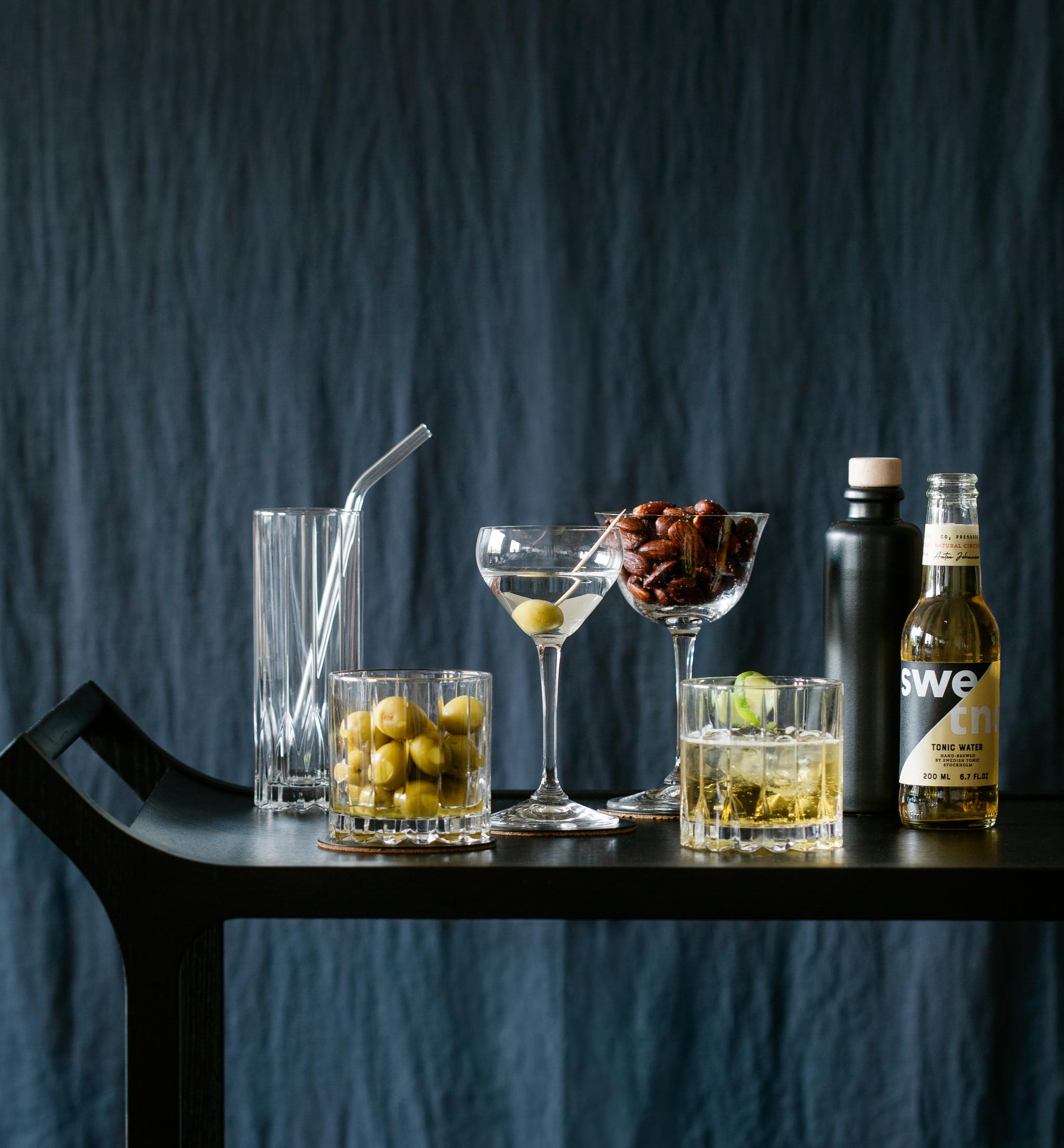 Glass med drinker og oliven på et bord