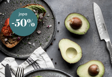 Keittiöasetelma, jossa on avokadoleipää, halkaistuja avokadoja, kokkiveitsi ja teksti 'jopa -50 %' alennuksesta.
