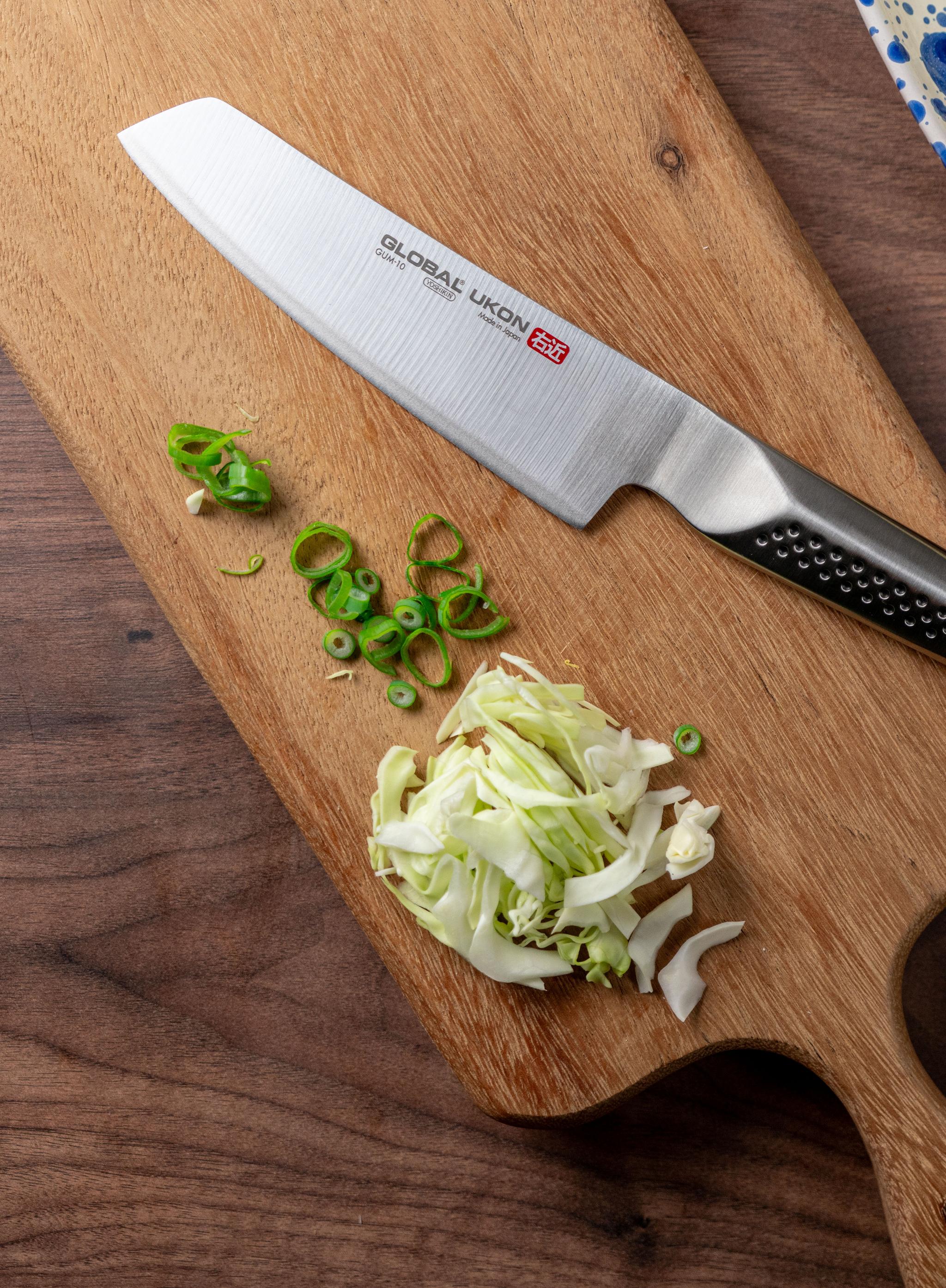 En grönsakskniv och spetskål på en skärbräda