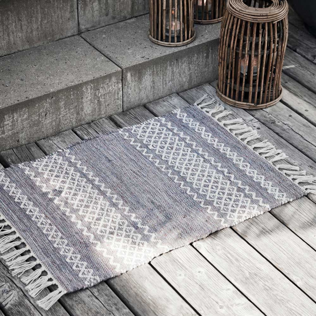 Mattor i grått med vitt mönster och fransar