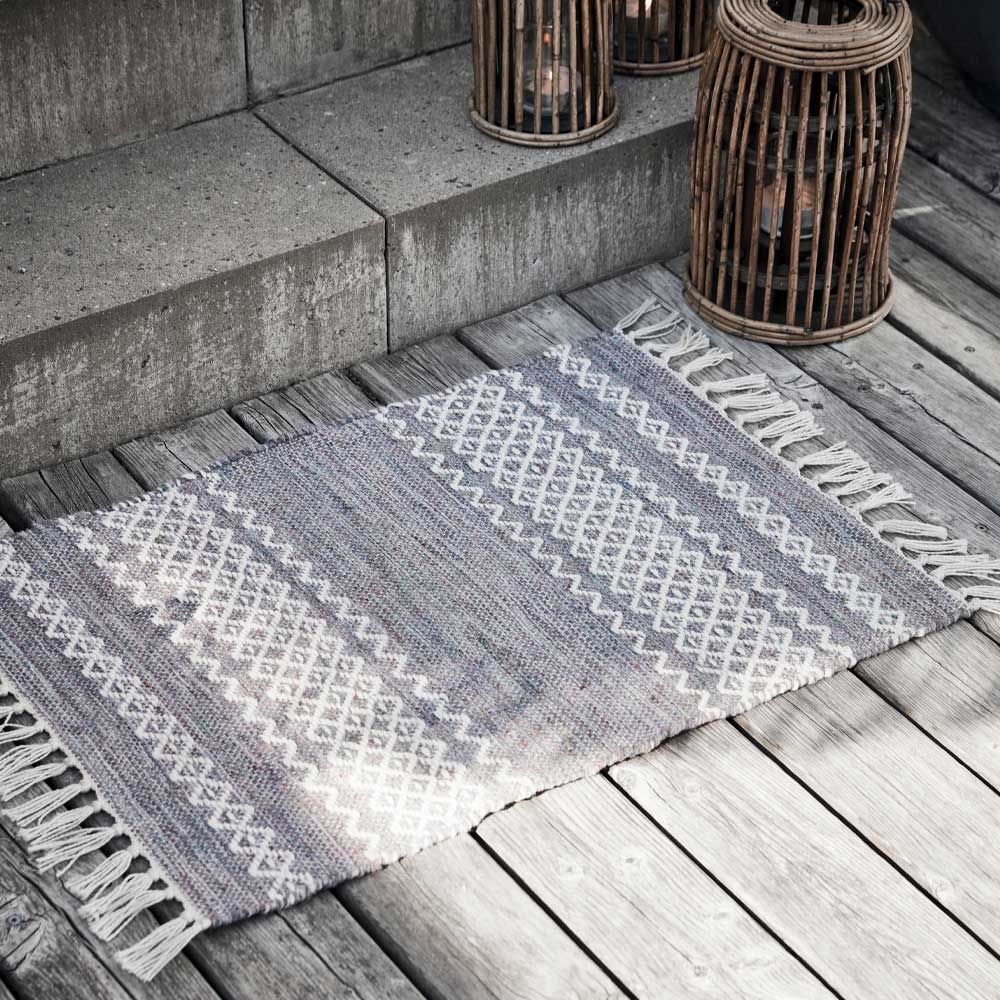 Mattor i grått med vitt mönster och fransar