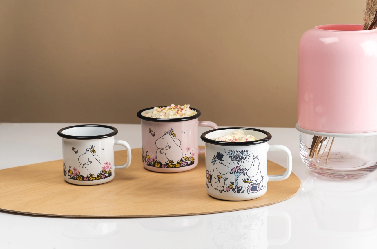 Mummikopp emalje stående på en bordbrikke i tre