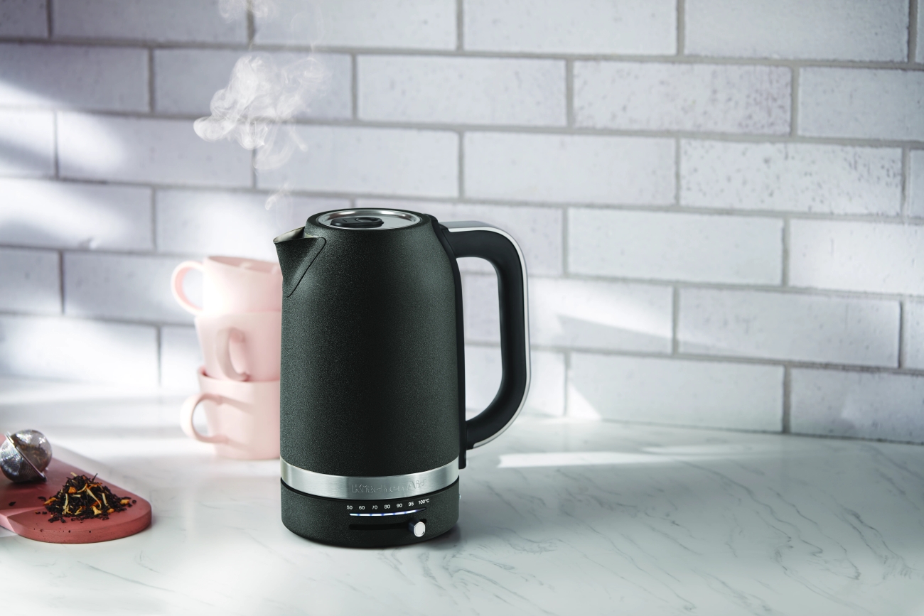 Kitchenaid vattenkokare i svart på en köksbänk av marmor med hett vatten i 