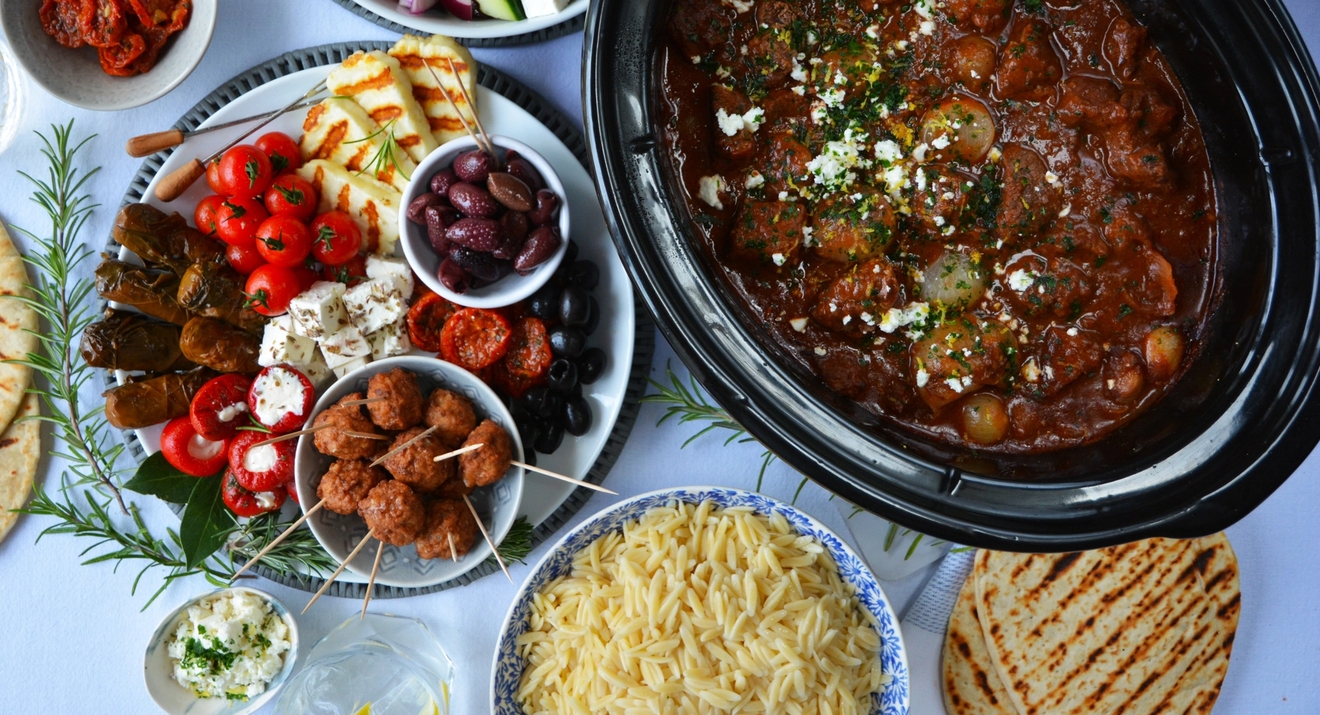 Slow cooker med timer svart på träbord, fruktskål i bakgrunden