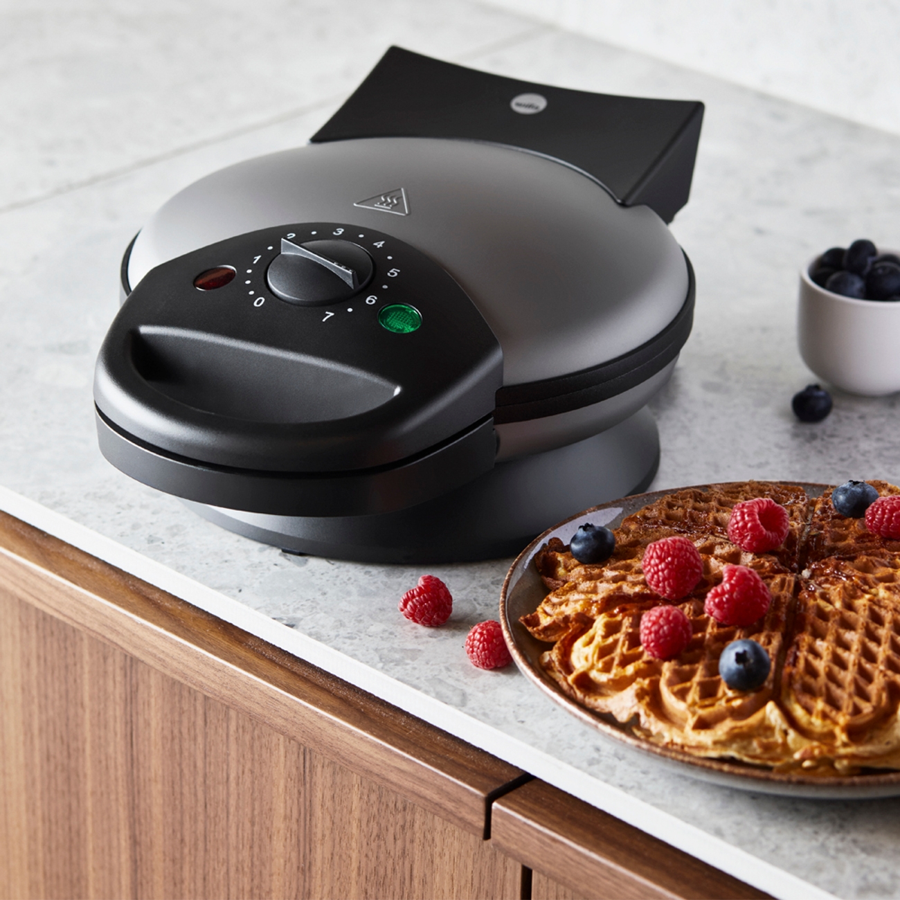 Wilfa våffeljärn med en nygräddad våffla med färska bär på