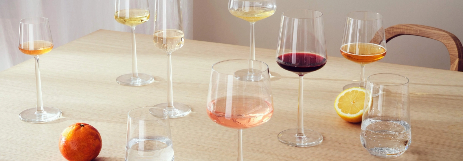 Iittala Essence lasit eri muotoisina ja kokoisina puupöydällä