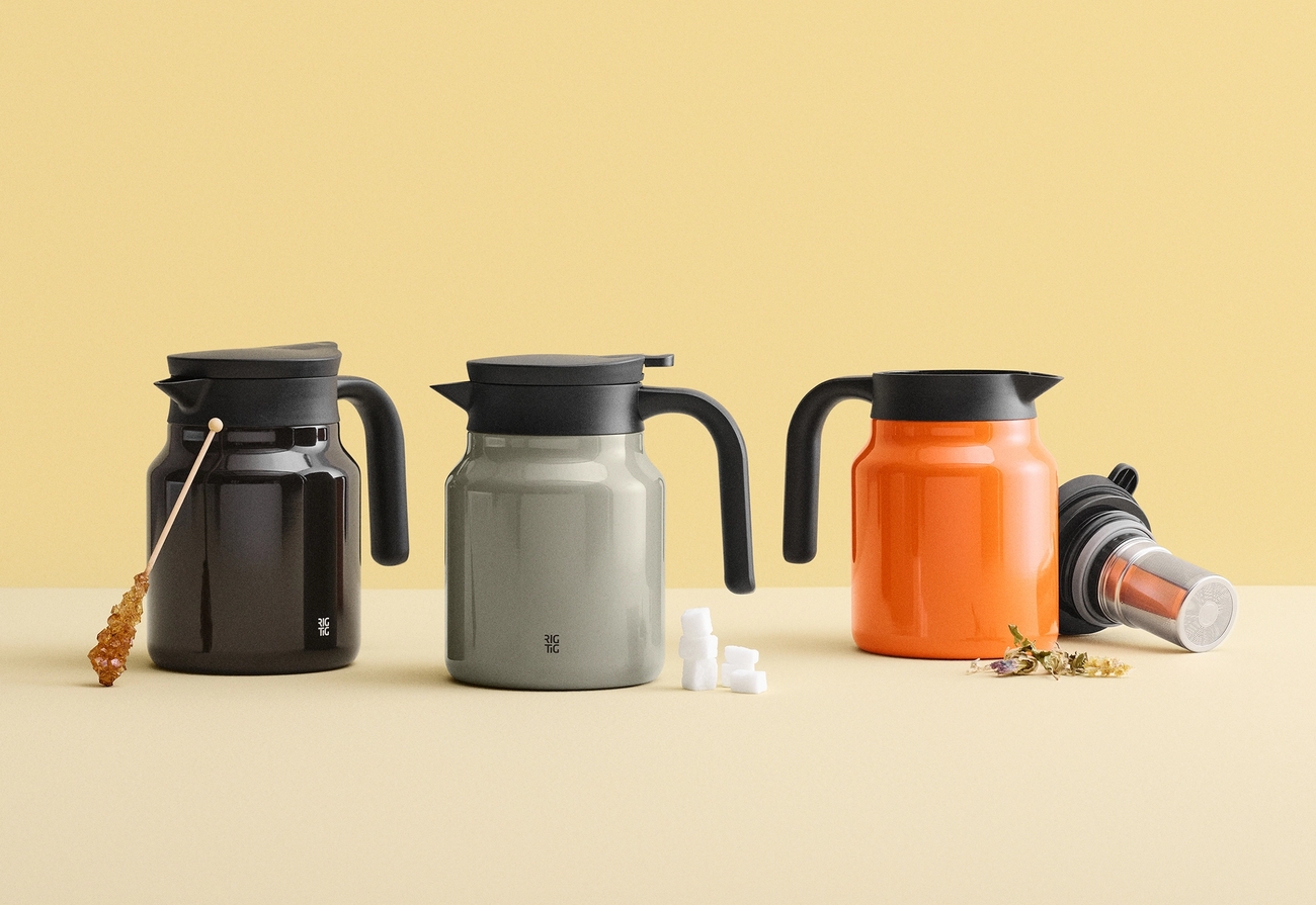 Tre mørkebrune, grå og oransje karafler med svarte lokk og håndtak, utstilt med sukker og tetilbehør.