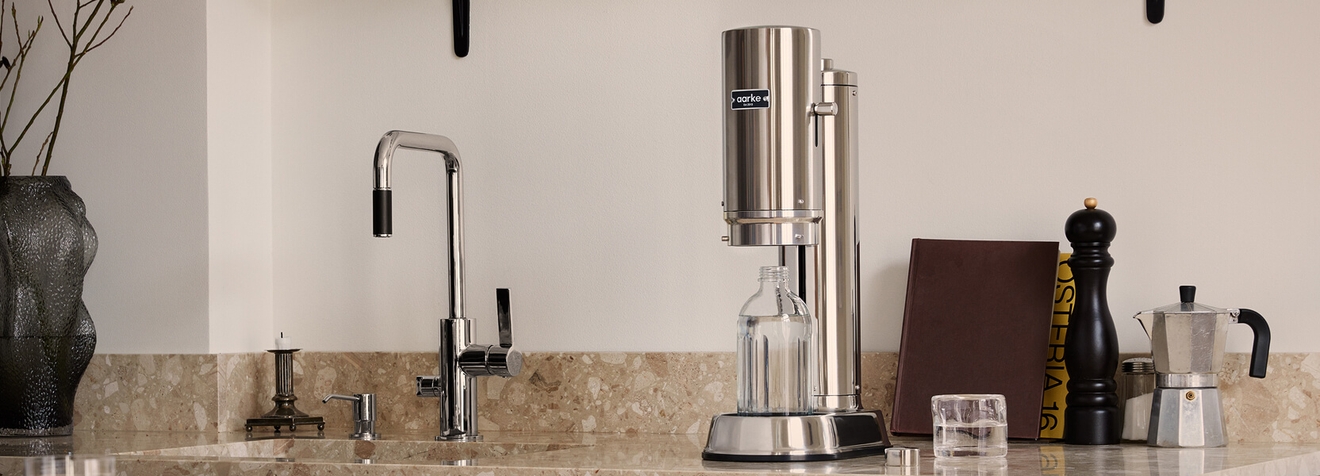 Kullsyremaskin i stål fra Aarke stående på en kjøkkenbenk