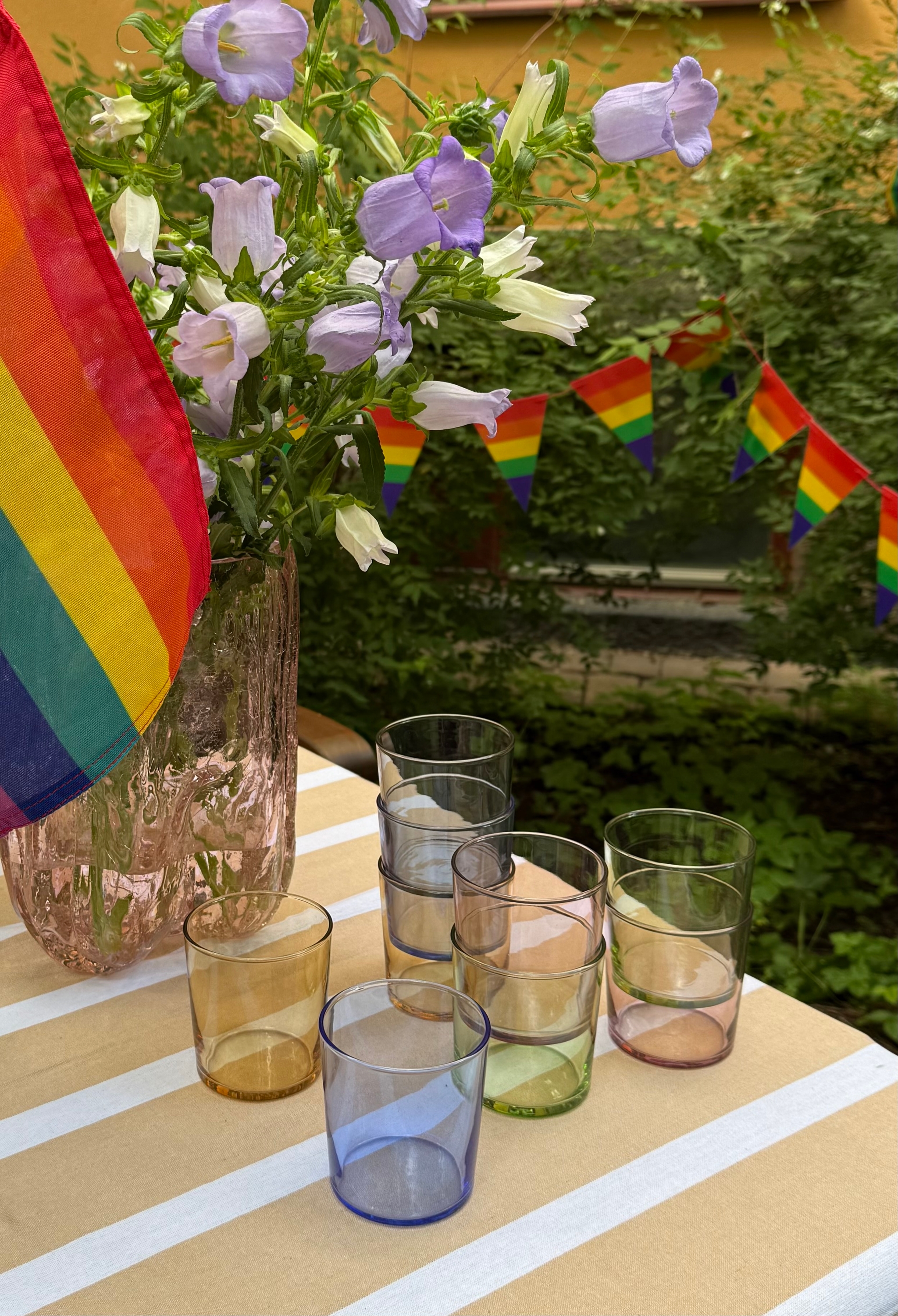 a table with a vase of flowers and glasses on it