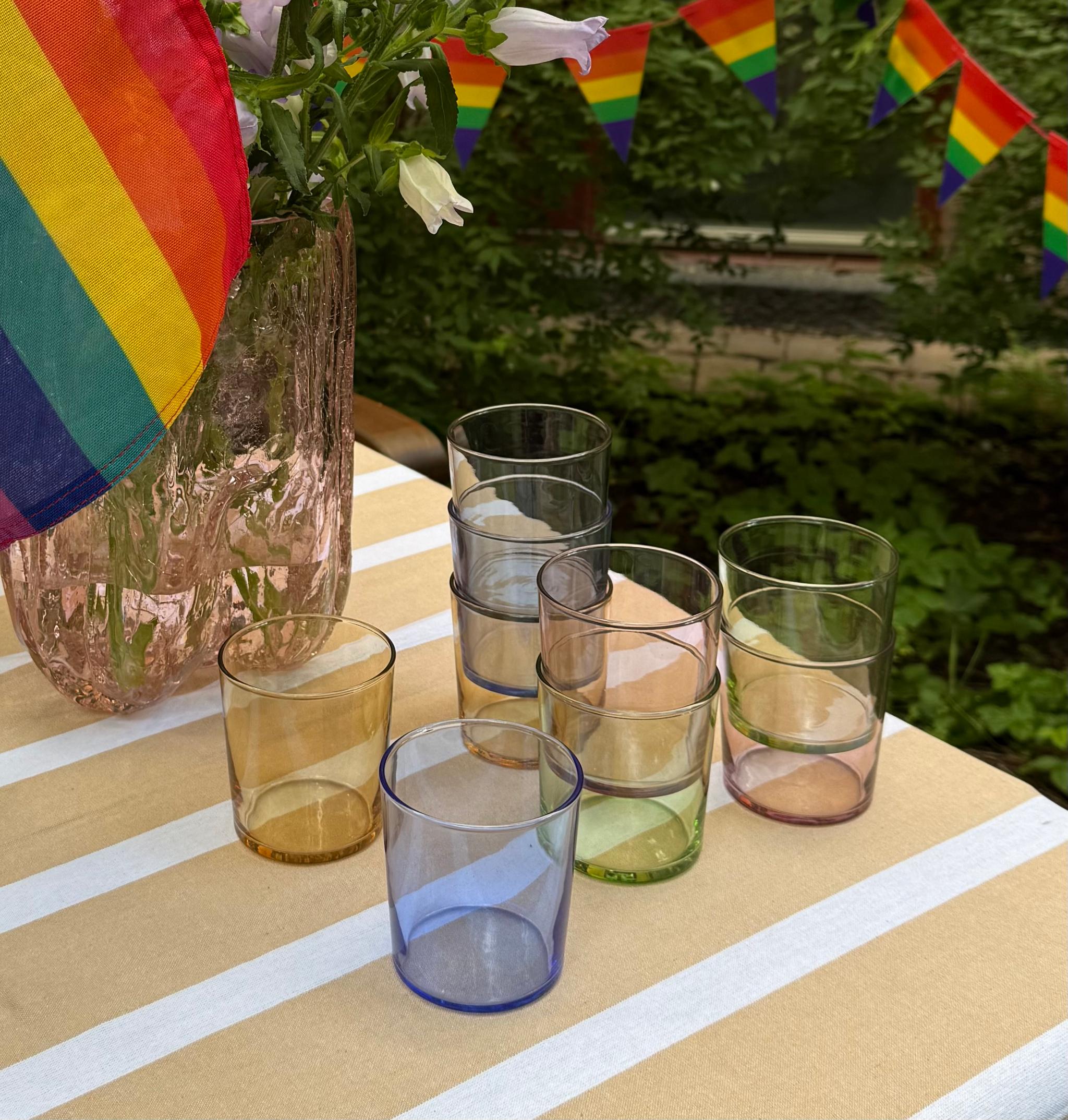 a table with a vase of flowers and glasses on it