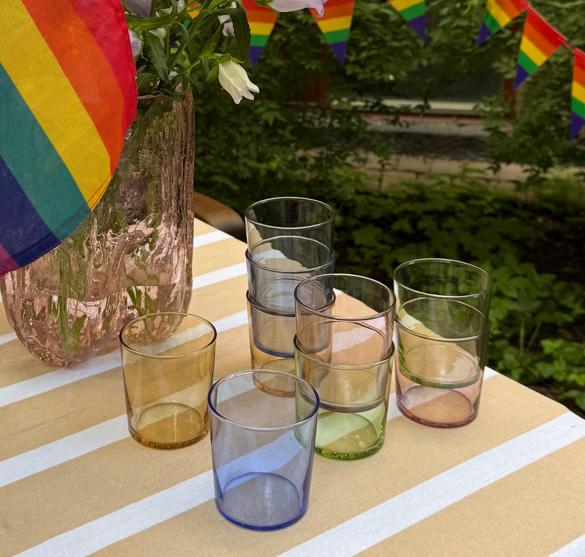 a table with a vase of flowers and glasses on it