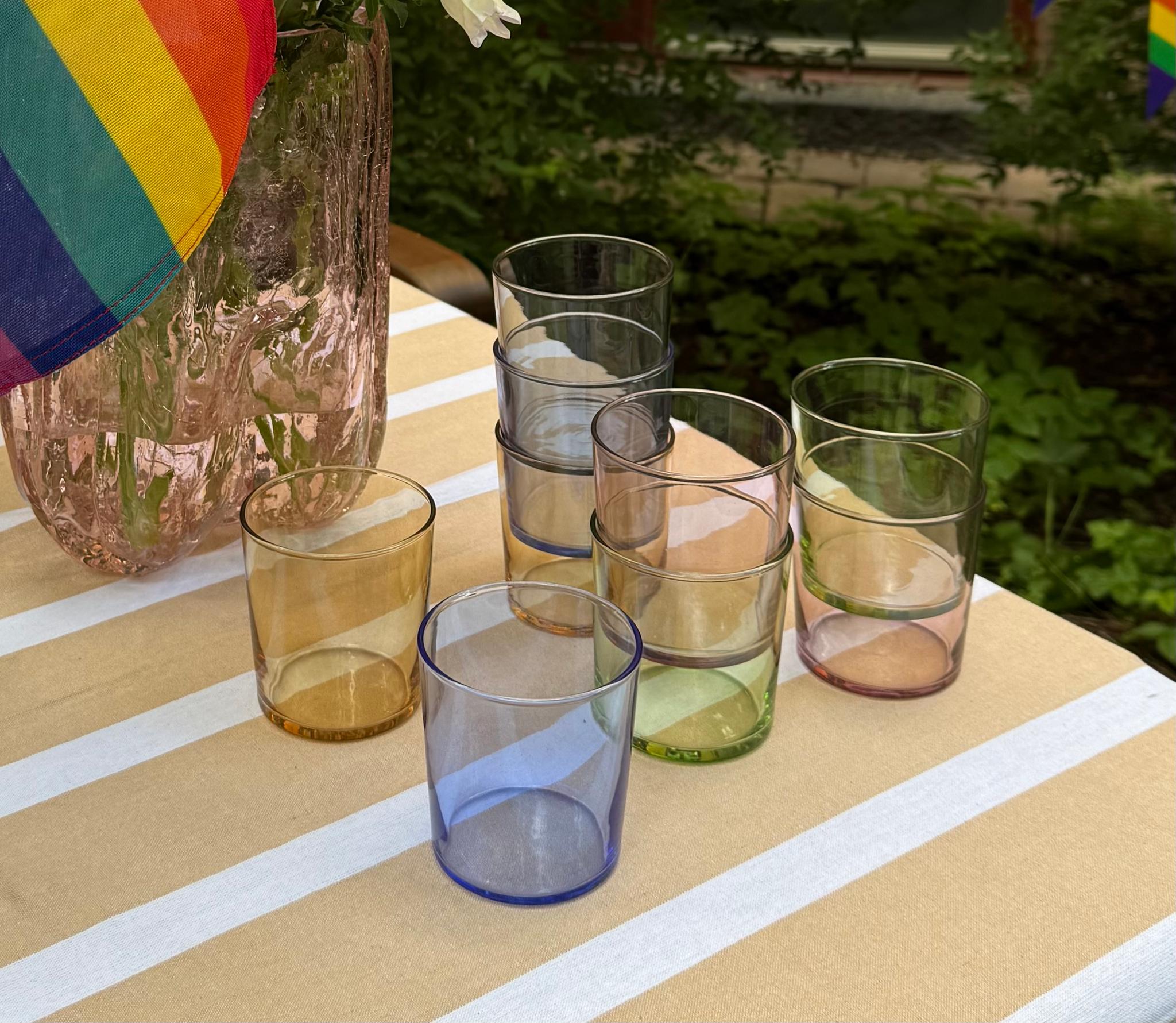a table with a vase of flowers and glasses on it