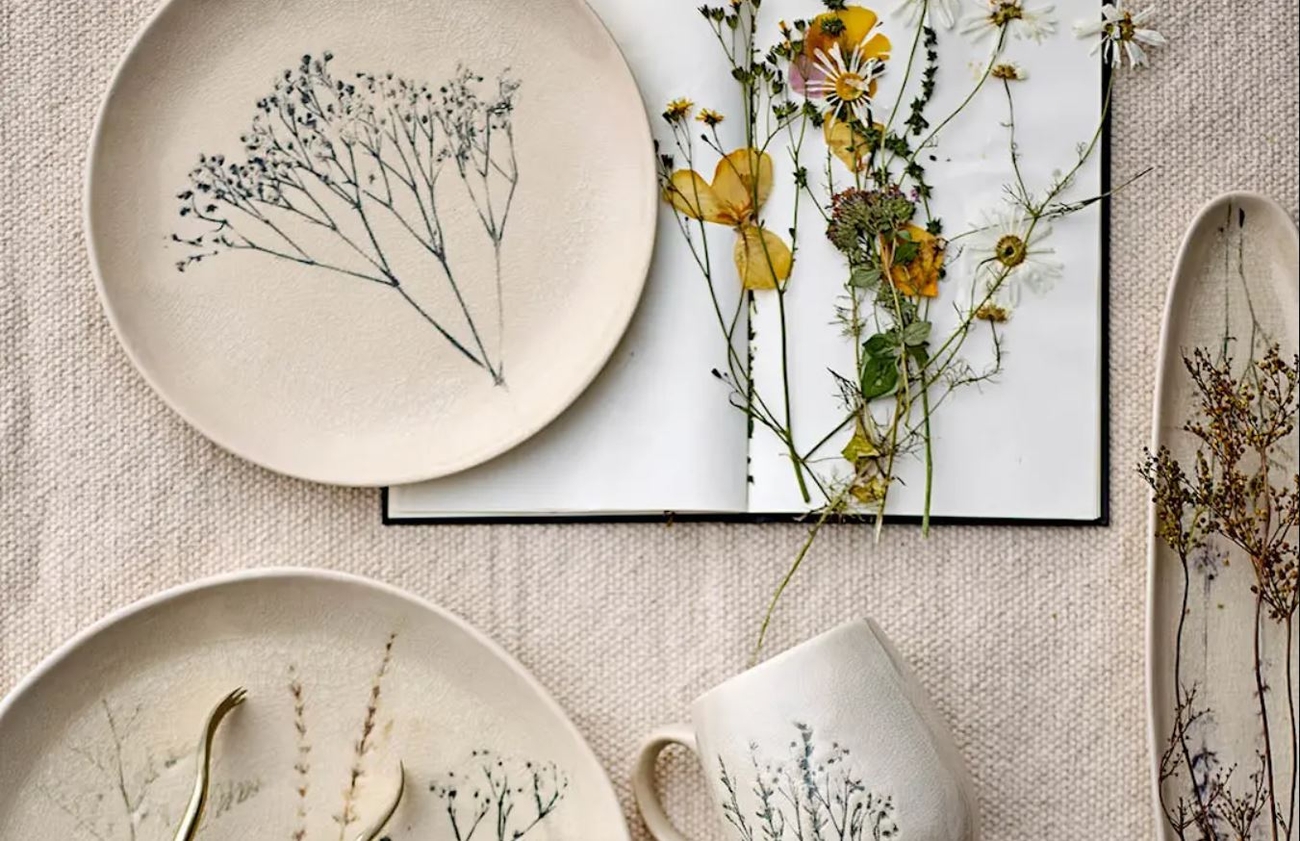 Bea handmålad tallrik och mugg med blommor på en beige linneduk