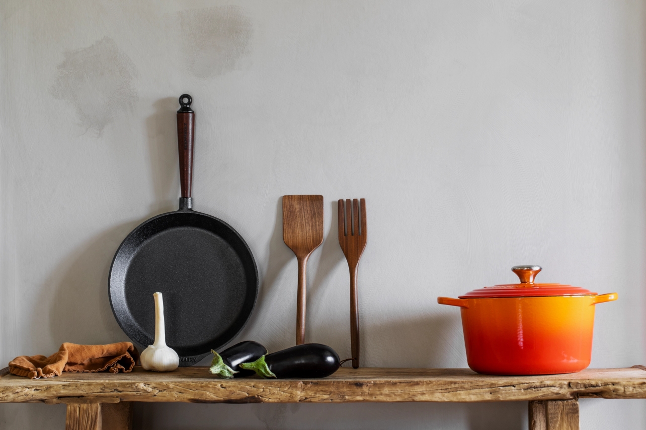Traditional stekpanna från Skeppshult med trähandtag mot grå vägg