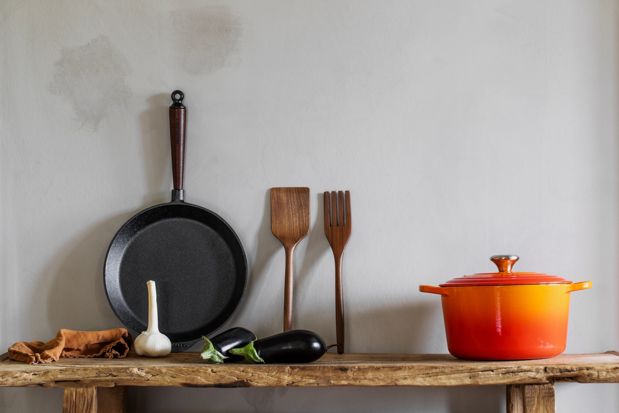 Traditional stekpanna från Skeppshult med trähandtag mot grå vägg
