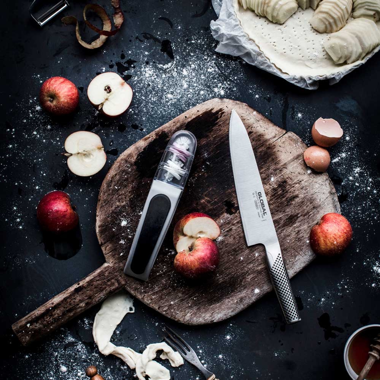 Fruktkniv på träskärbräda med delade äpplen