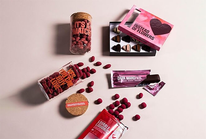 Simply Chocolate olika produkter utspridda på ljusrosa bakgrund