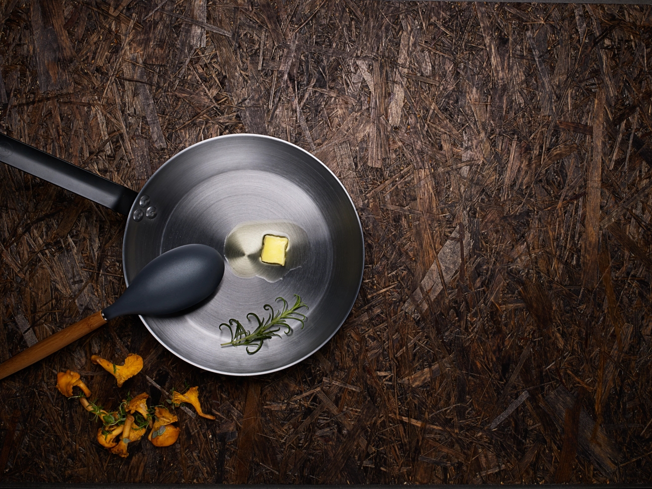 Hiiliteräspannu, jossa sulatettu voi ja rosmariini 