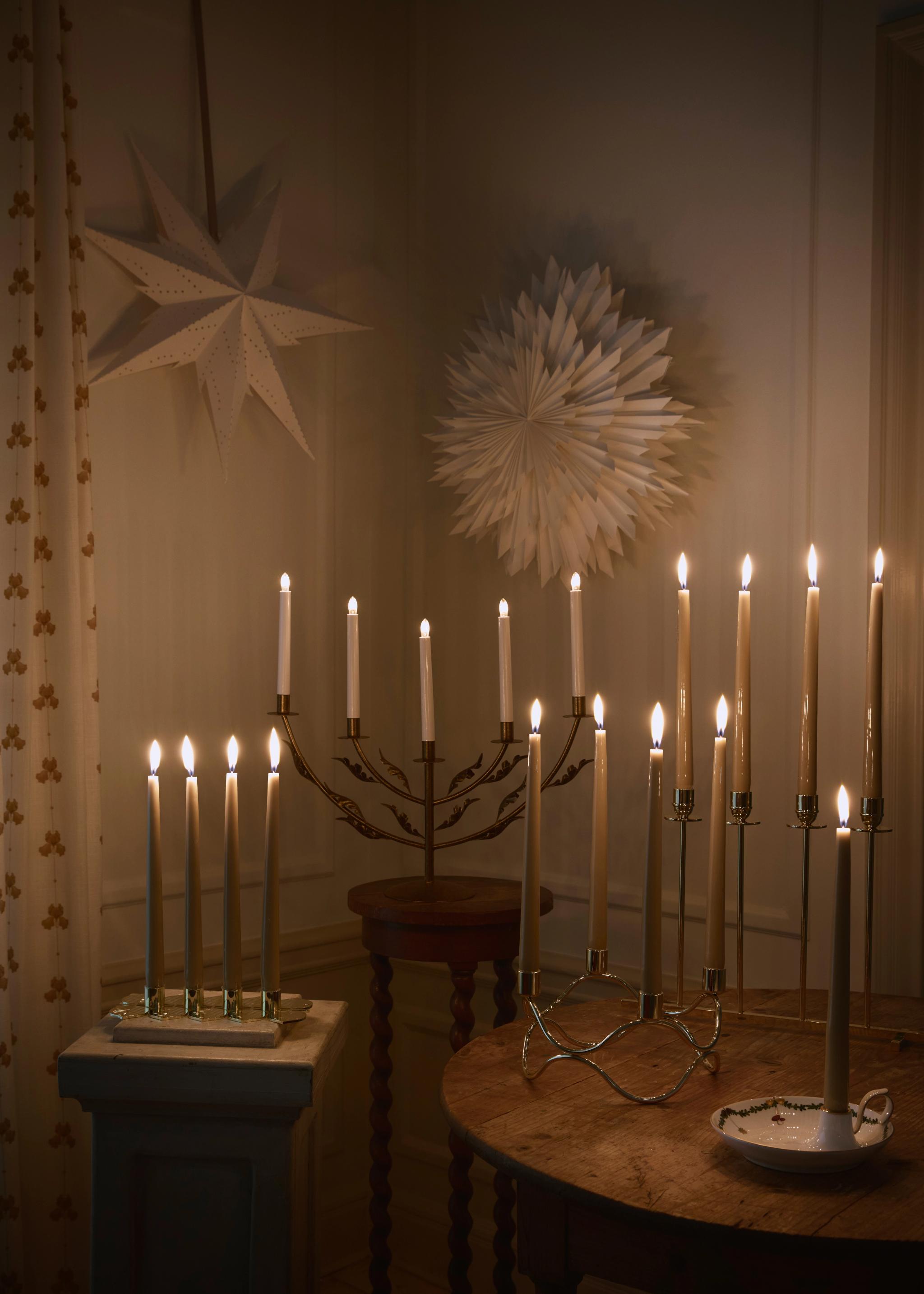 Stämningsfull belysning med tända adventsljusstakar och julstjärnor