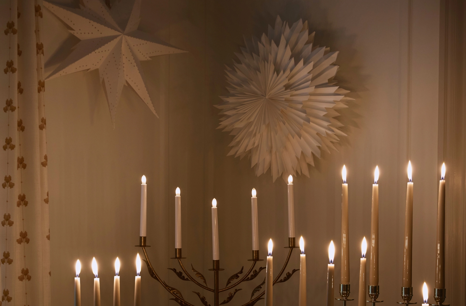 Stämningsfull belysning med tända adventsljusstakar och julstjärnor