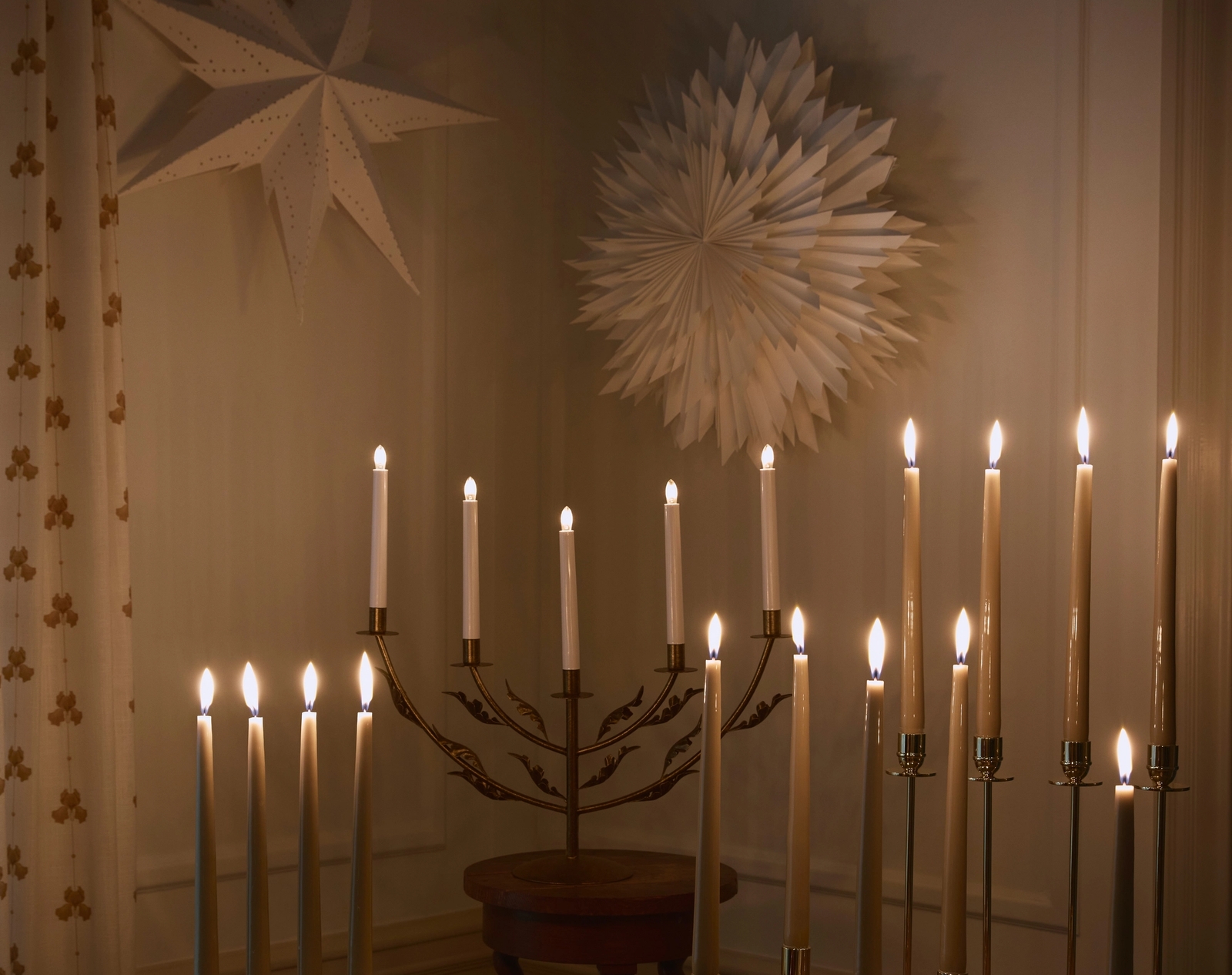 Stämningsfull belysning med tända adventsljusstakar och julstjärnor