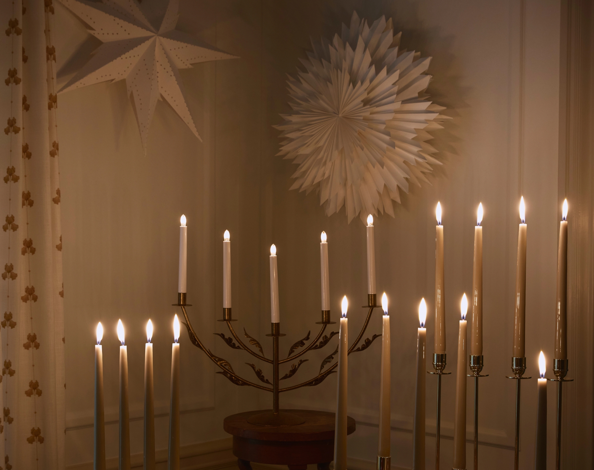 Stämningsfull belysning med tända adventsljusstakar och julstjärnor