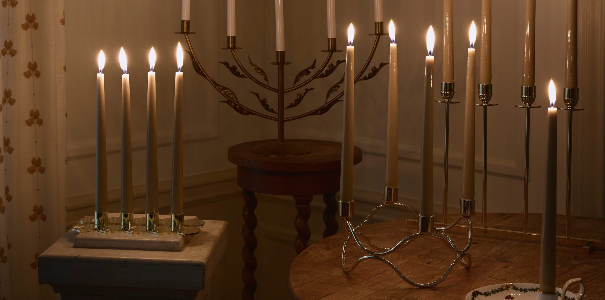 Et bord med adventsstaker med levende lys