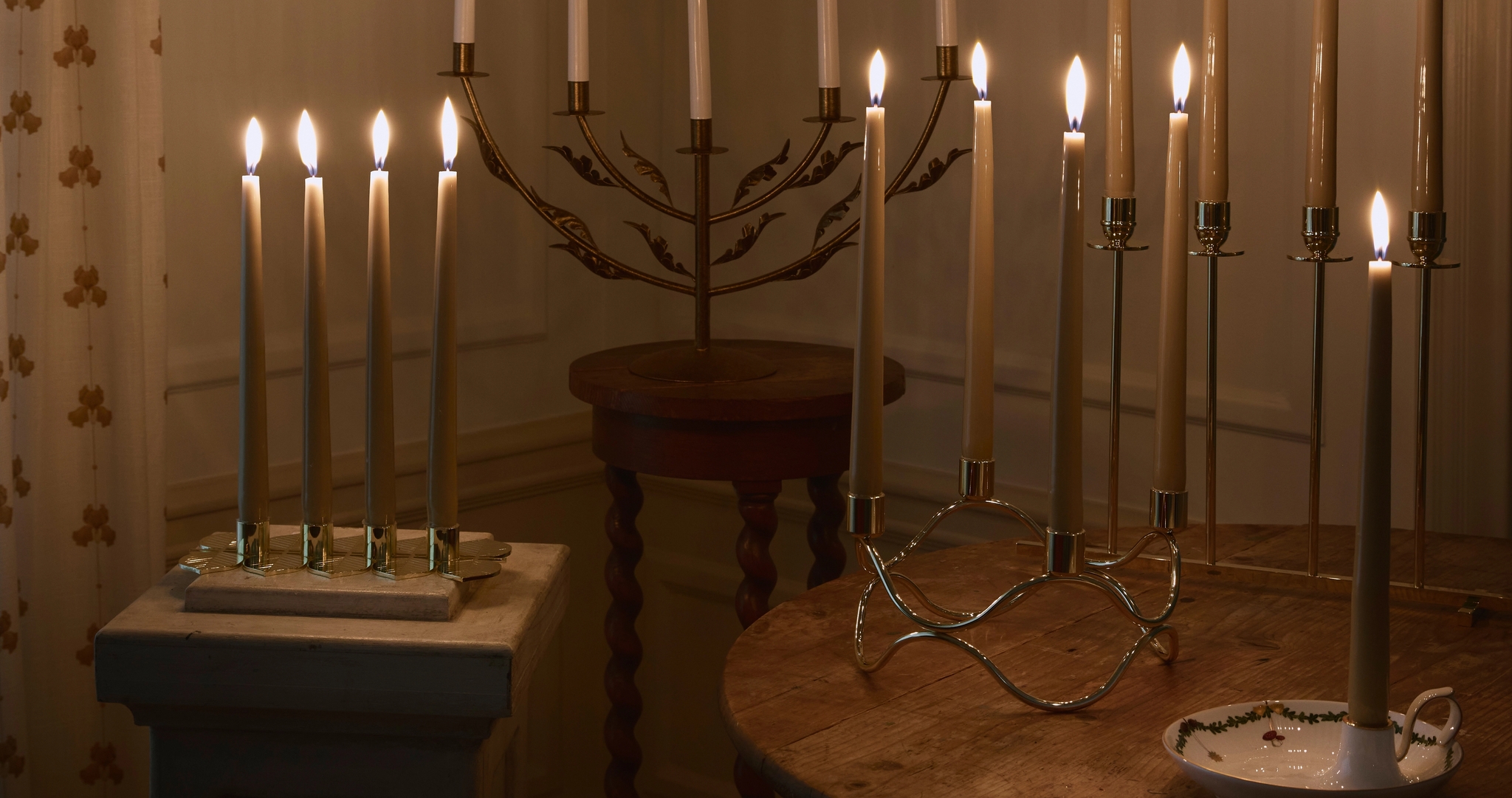 Et bord med adventsstaker med levende lys