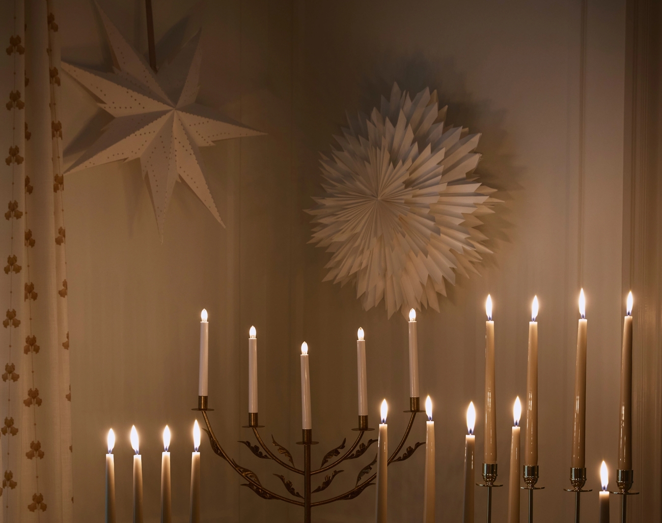 Tunnelmallista valaistusta sytytetyillä adventtikynttilöillä ja joulutähdillä