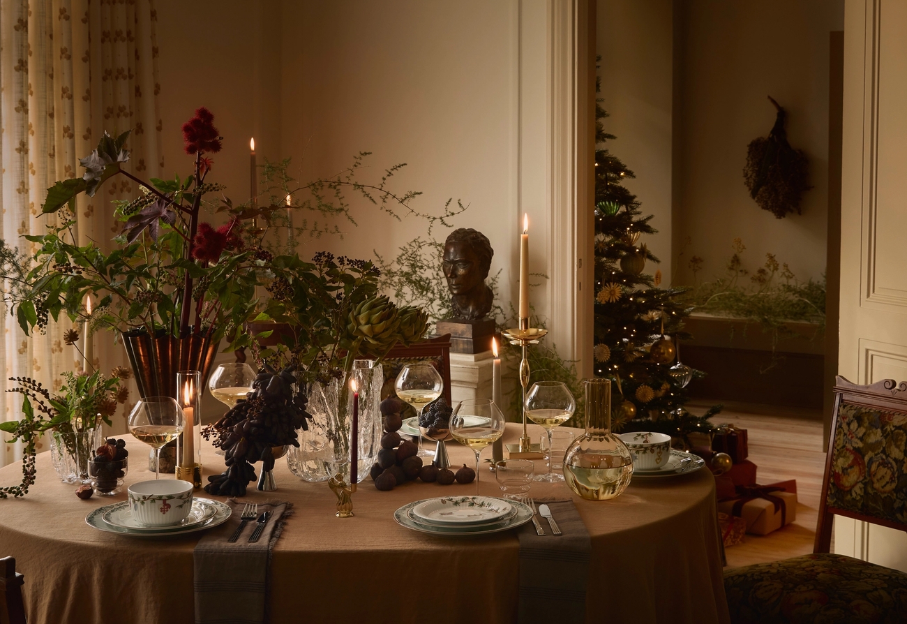 Ett vackert dukat bord till jul med tända ljus och blommor