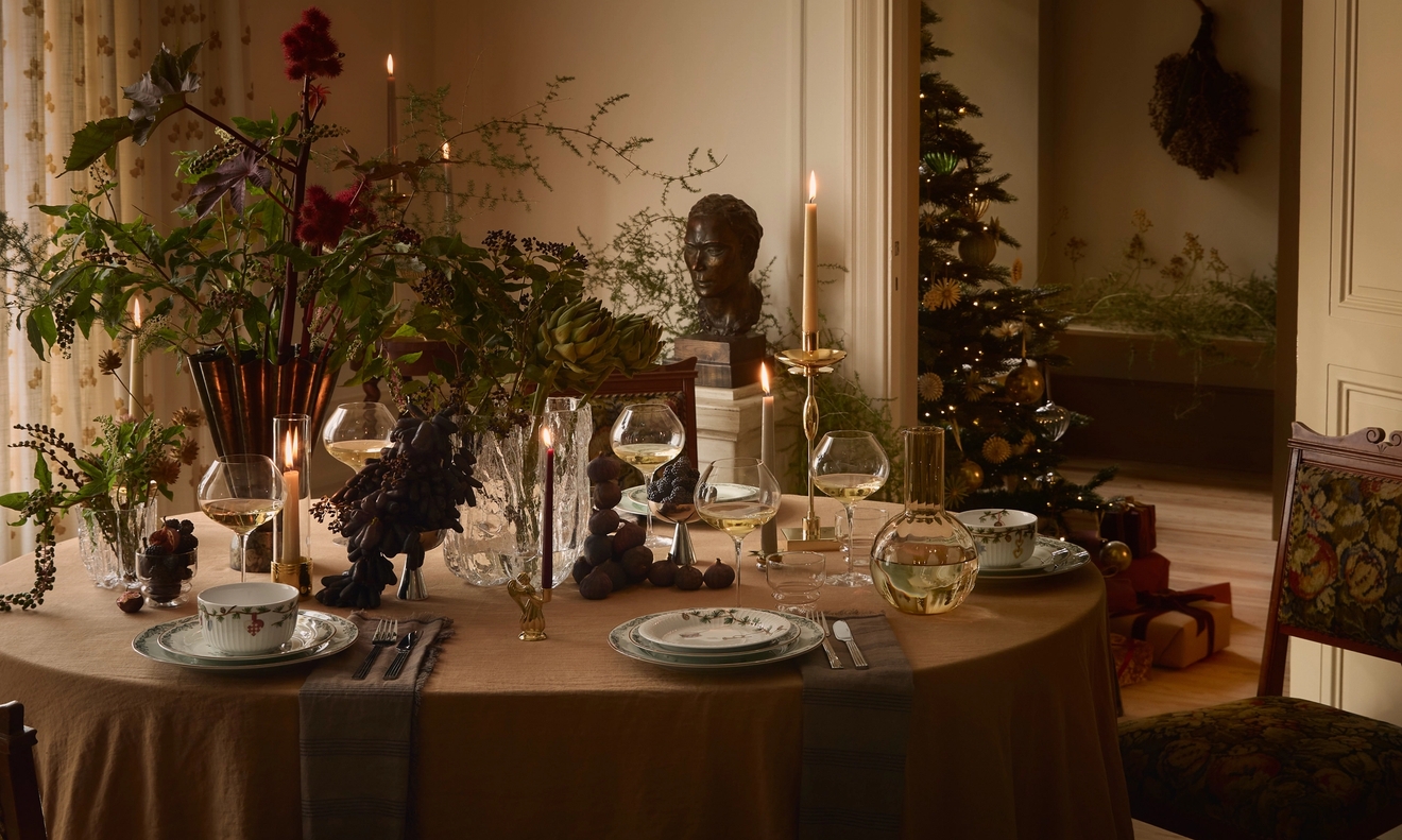 Ett vackert dukat bord till jul med tända ljus och blommor