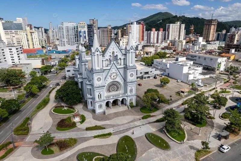Vista aérea da Igreja Matriz do Santíssimo Sacramento, em estilo neogótico, com a praça em frente e prédios do Centro de Itajaí ao fundo