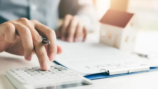Homem calculando condições de refinanciamento de imóvel.