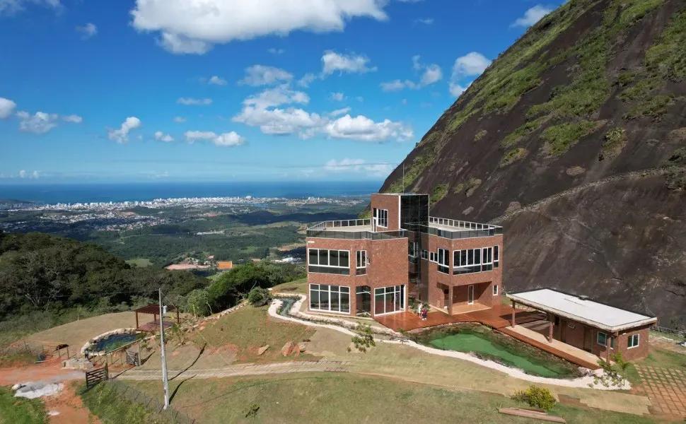 Casa moderna de tijolos e vidro em encosta, com piscina e vista para o mar
