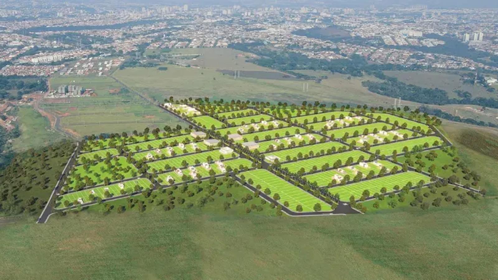 Vista aérea de um loteamento residencial com ruas arborizadas e lotes demarcados, tendo a cidade ao fundo.