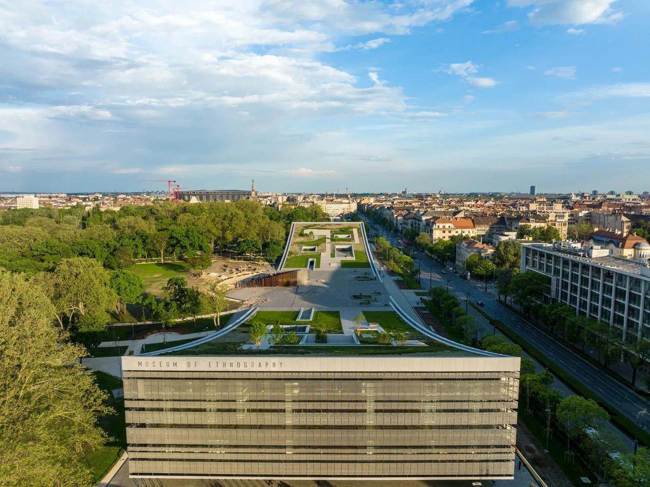 Vista aérea do Museu de Etnografia, com a fachada de trama metálica e as coberturas verdes em rampa voltadas para o parque