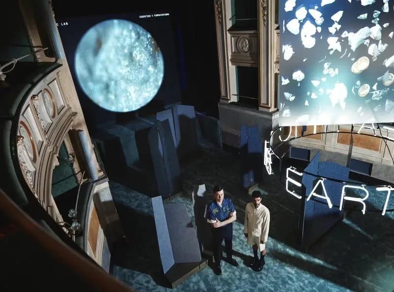Instalação Earthic Lab no Teatro Gerolamo, com telões e esculturas iluminadas na plateia do teatro