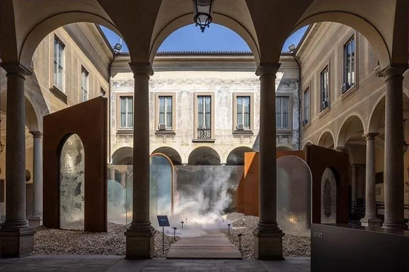 Portais de vidro fundido e névoa no pátio porticado do Palazzo Isimbardi