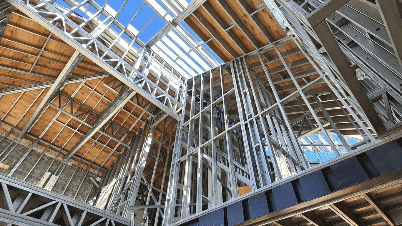 Estrutura de steel frame vista de baixo, com montantes e treliças de aço galvanizado e piso de madeira