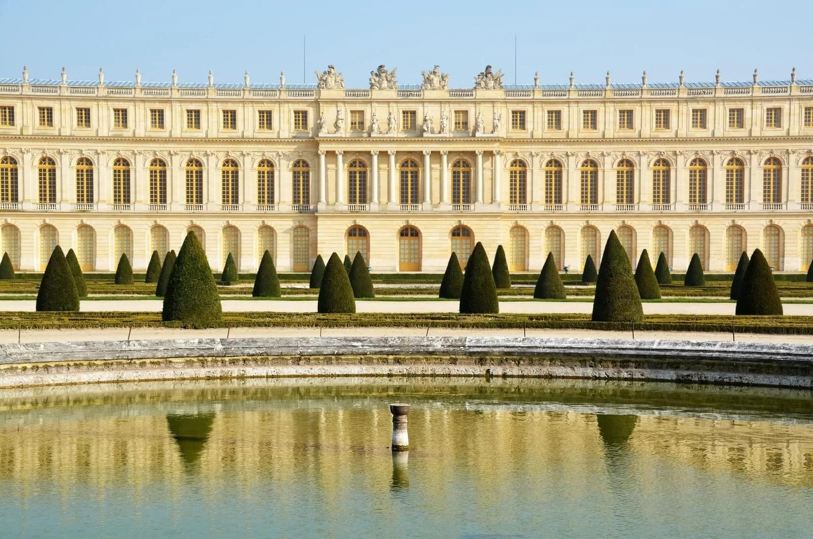 Fachada do Palácio de Versalhes Fachada clássica do Palácio de Versalhes refletida em um espelho d'água