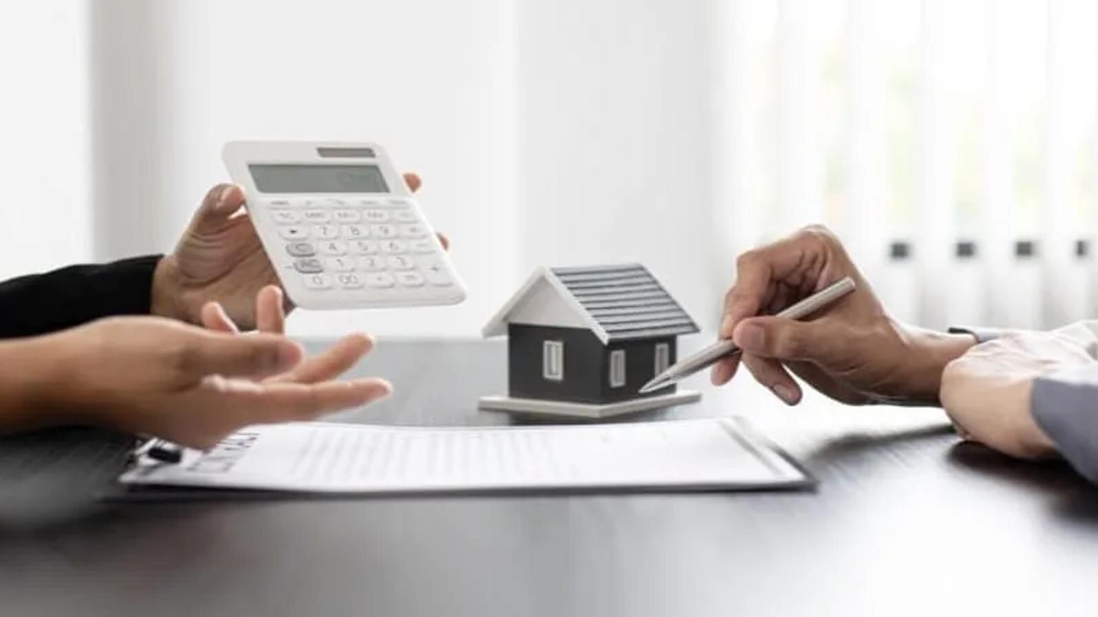 Duas pessoas calculando impostos em negociação do imóvel.